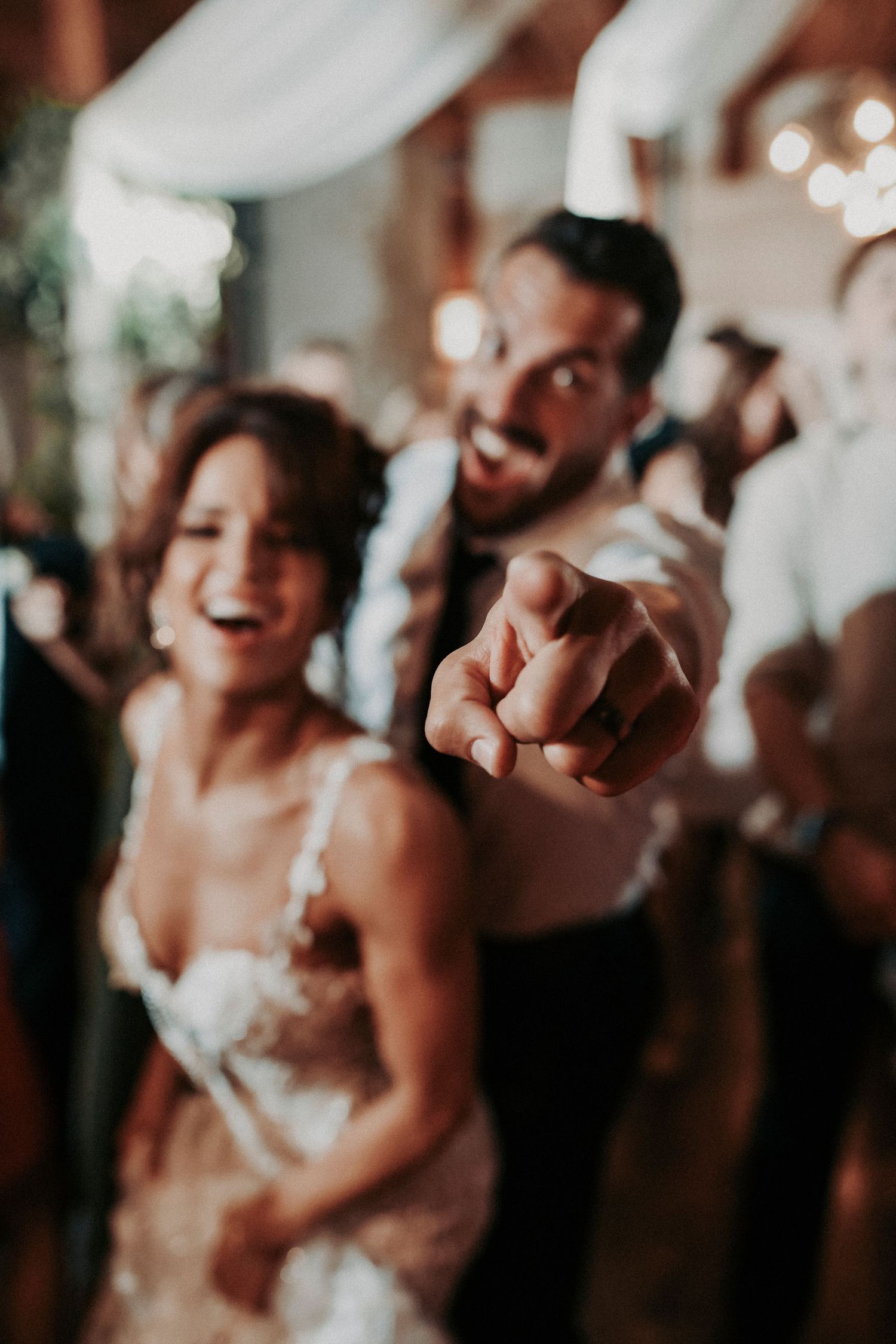 Megan stealing Joel’s sunglasses while snuggling at the reception