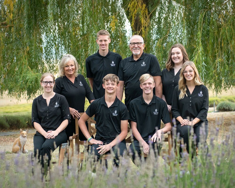 team of eight employees outside environmental group portrait of Spokane company by professional photographer Luba Wold in Post Falls