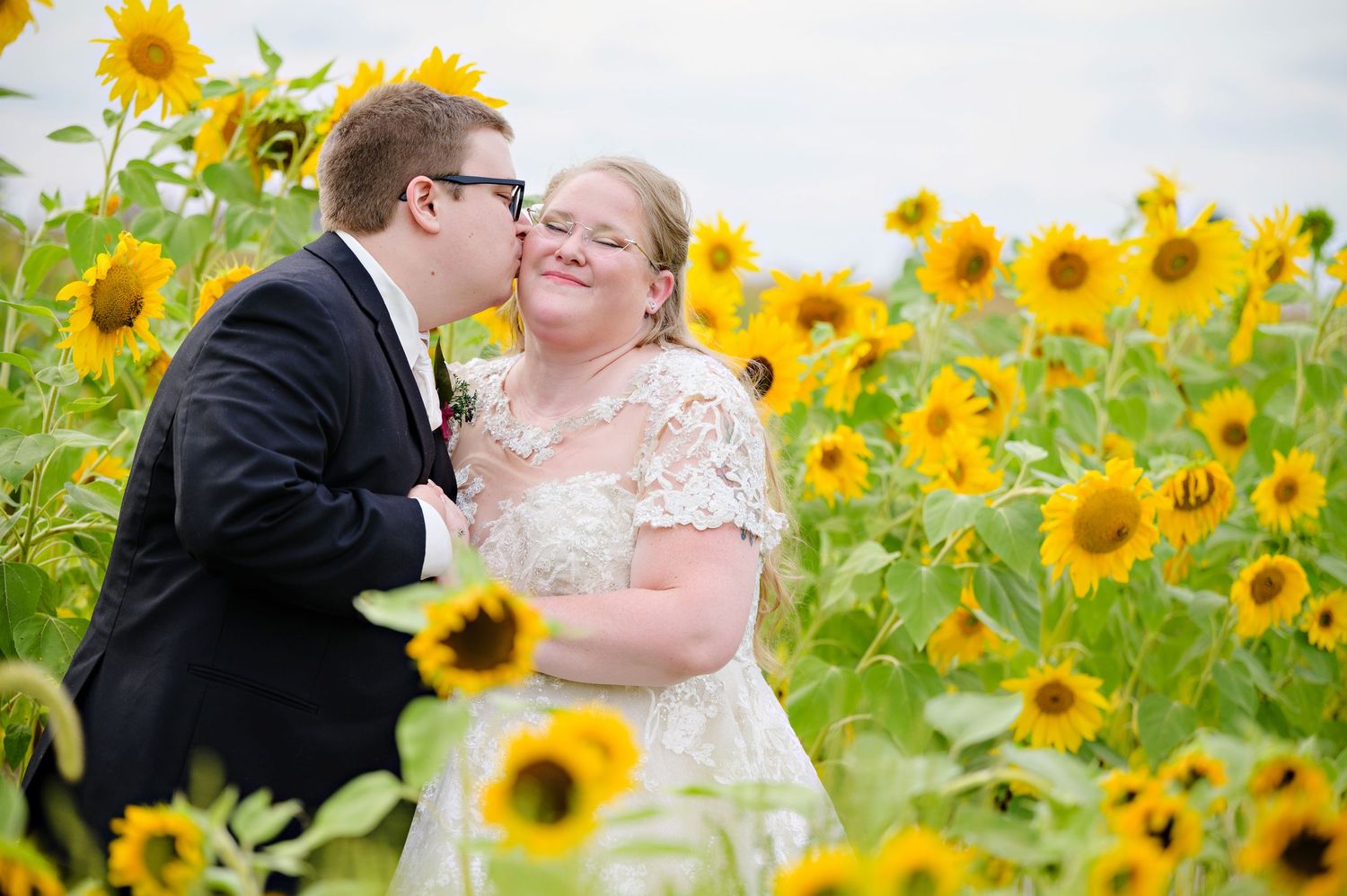 Bride and Groom posing in a sunflower field at Whetstone Center after their wedding ceremony in Louisville Ohio in September.