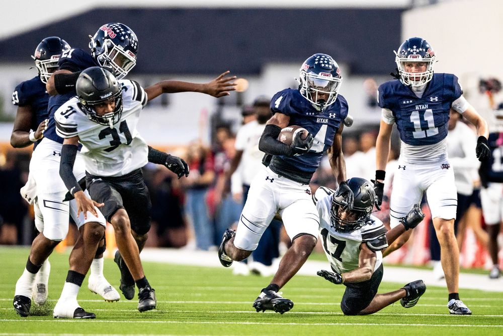High school football player number 4 breaks tackles during an exciting night game run.
