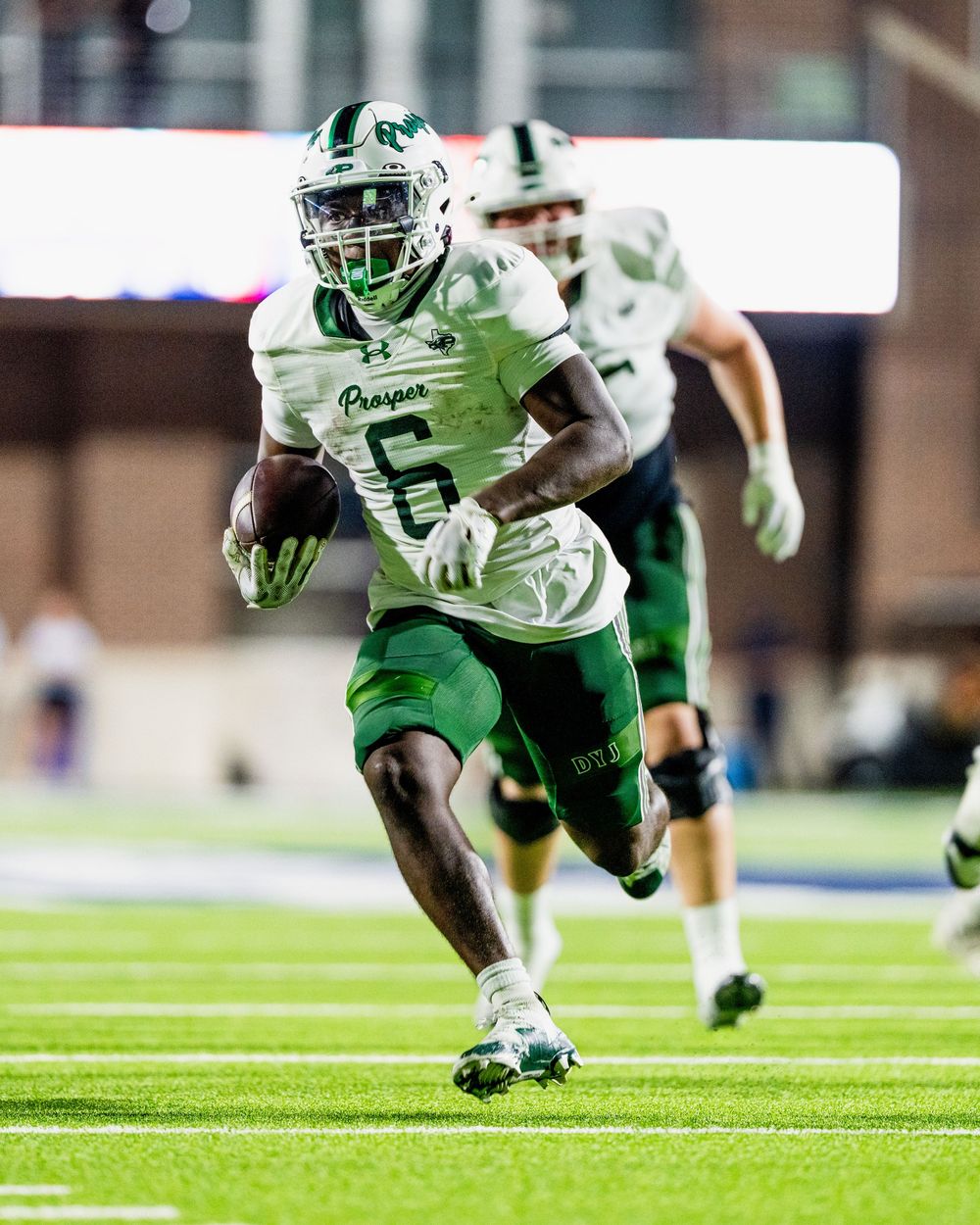 Prosper Eagles football player number 6 runs with the ball during a night game.