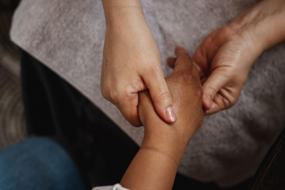 Close-up of an adult gently holding a baby's small hand, symbolizing love, care, and family bonding.