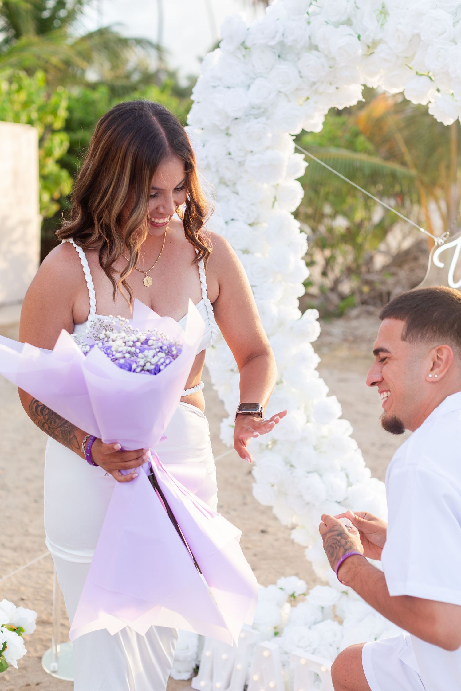 Marriage proposal. Man, woman, and decorative setup with white flower heart overlooking the ocean in Río Grande, Puerto Rico.