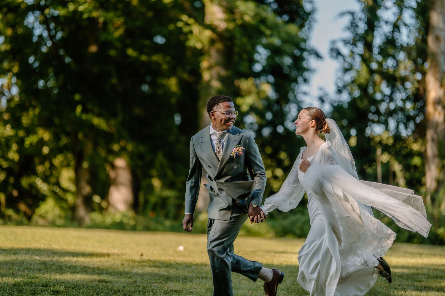 Newlywed couple kissing during sparkler send-off at outdoor evening wedding reception with guests celebrating.