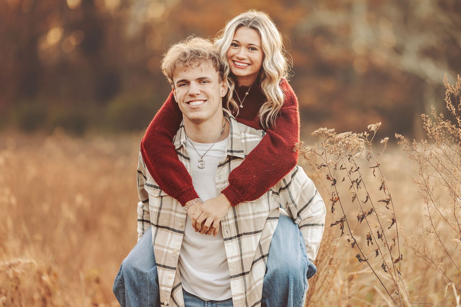 Couple sharing a romantic embrace outdoors in autumn golden hour light, surrounded by fall foliage.