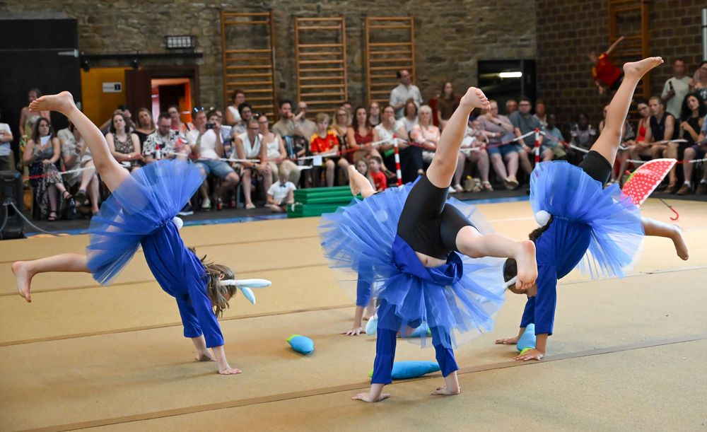 Trois gymnastes en tutus bleus, figure acrobatique
