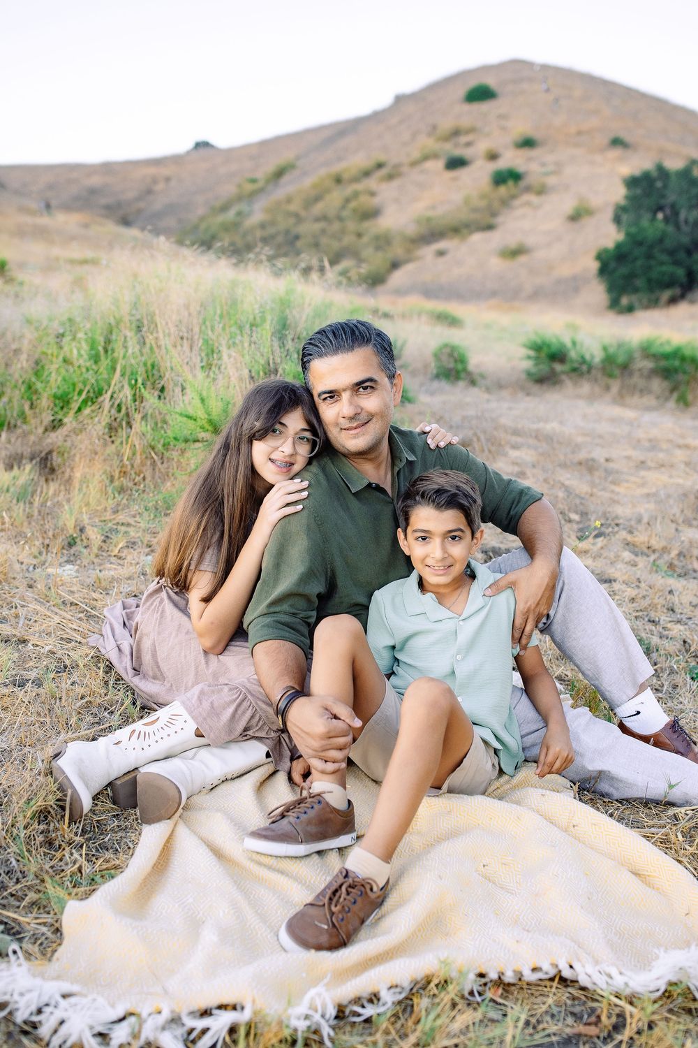Family sitting together outdoors during a lifestyle family photography session in Los Angeles.
