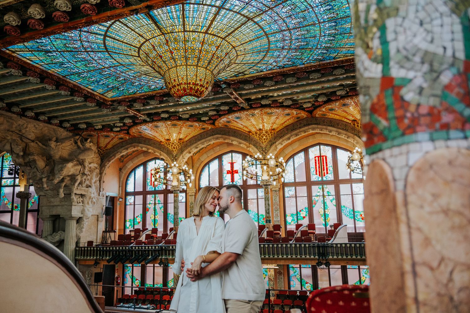 An intimate maternity portrait of a couple surrounded by lush gardens and unique, detailed architecture.