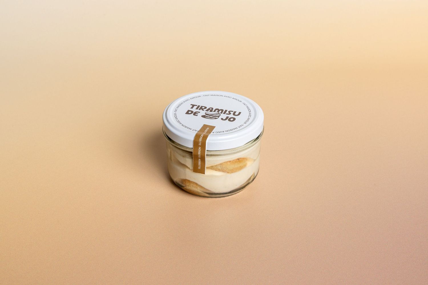 Via Bellini natural spice blend in a glass jar with black lid, displayed on a stone tile against a beige background.