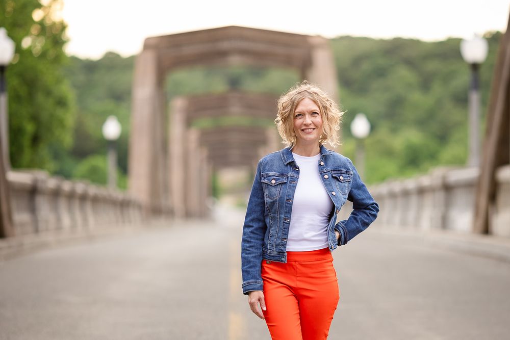 Real estate agent standing on the historic Cotter Bridge during a personal branding session in Cotter, Arkansas