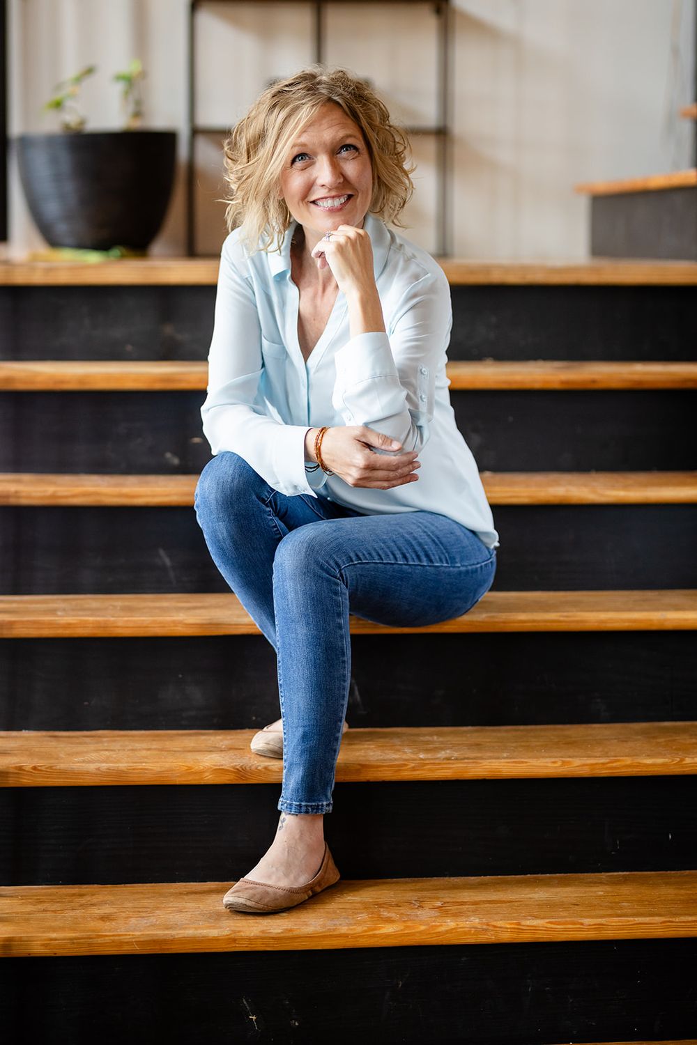Realtor sitting on steps with a coffee for a relaxed personal branding session in Gassville, Arkansas