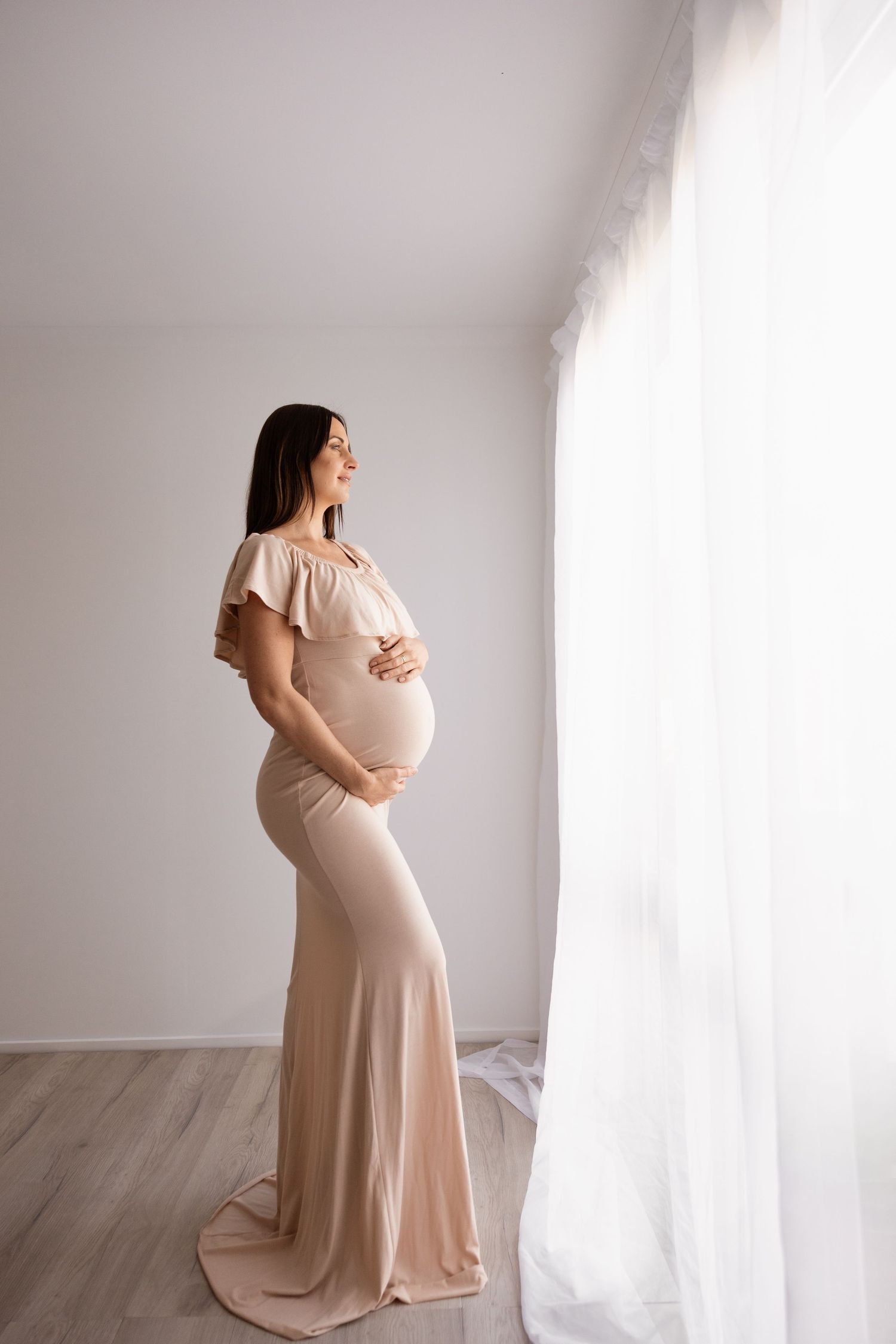 mum holding bump during maternity session in bishopdale studio