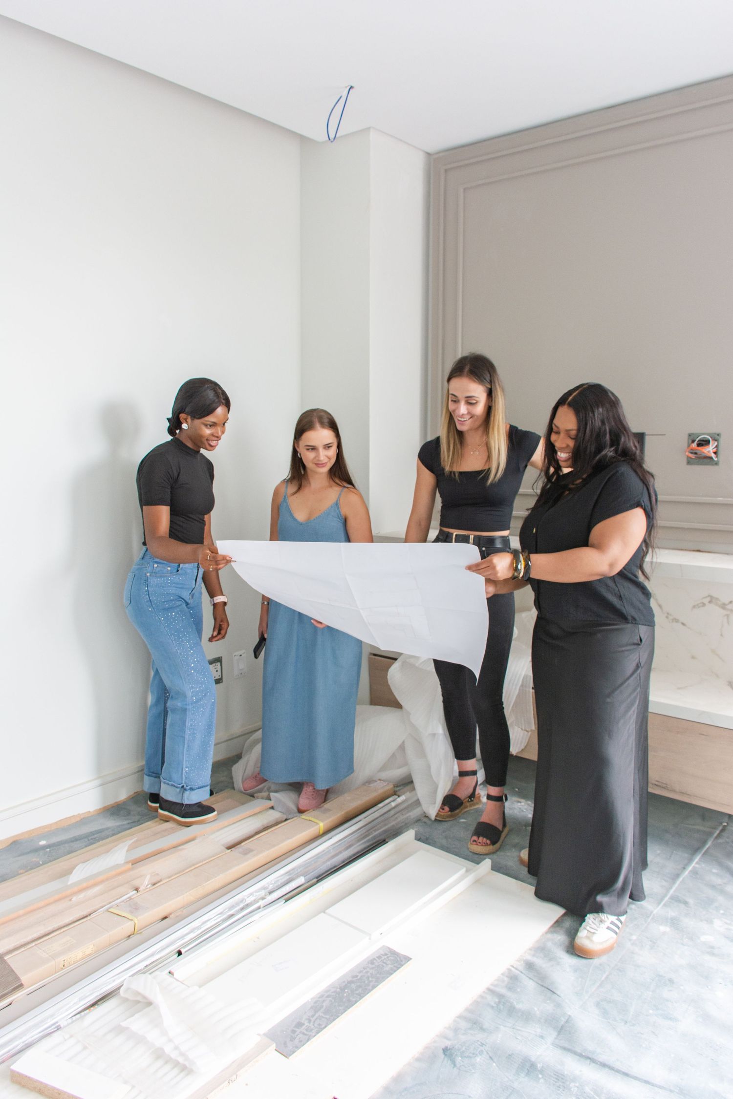 An interior design team in Johannesburg reviewing architectural blueprints together in a room under renovation with marble accents.