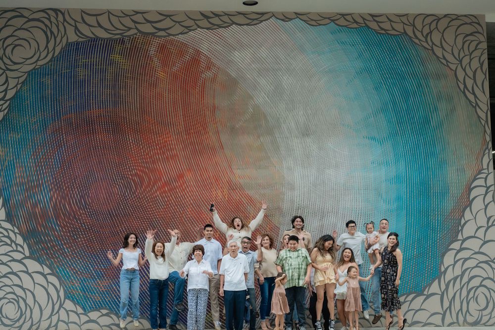 Large family group in front of a Kakaako mural.