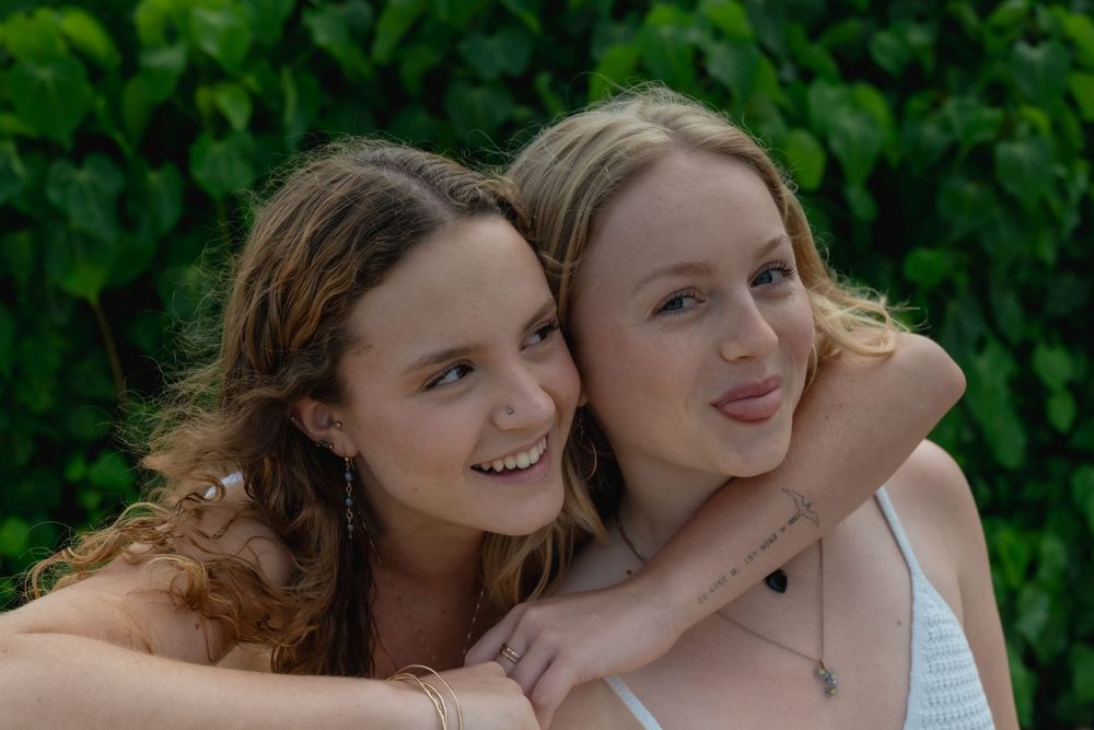 Two sisters hugging and making funny faces to the camera.