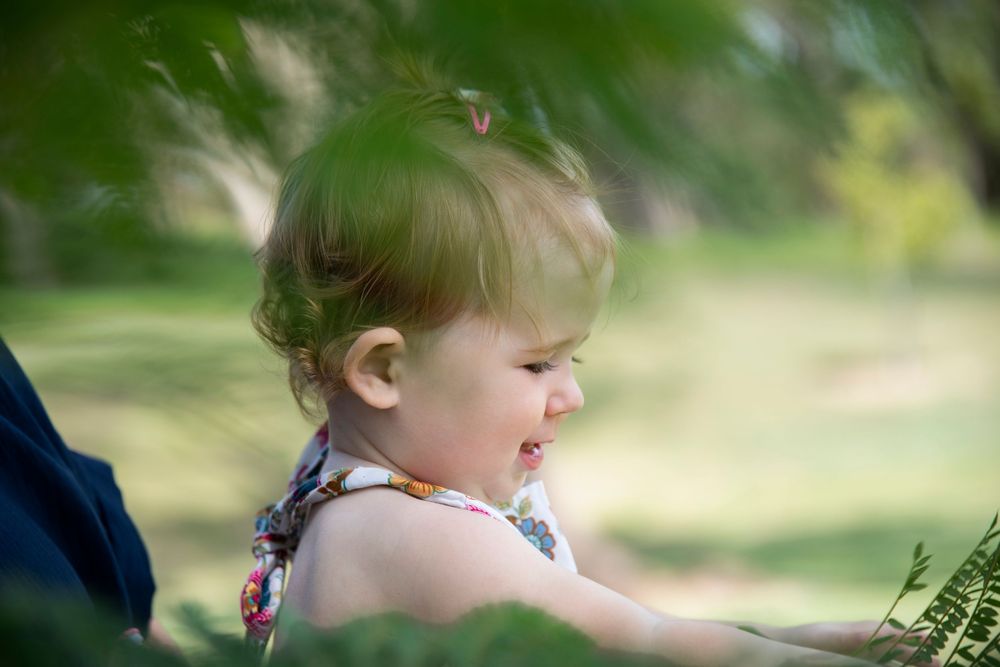 photo of a little girl through a fern leaf
