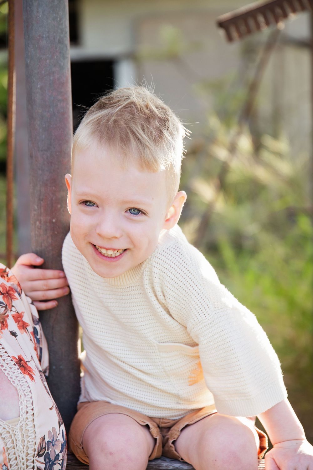cheeky boy hugging a pole and has a beautiful big smile