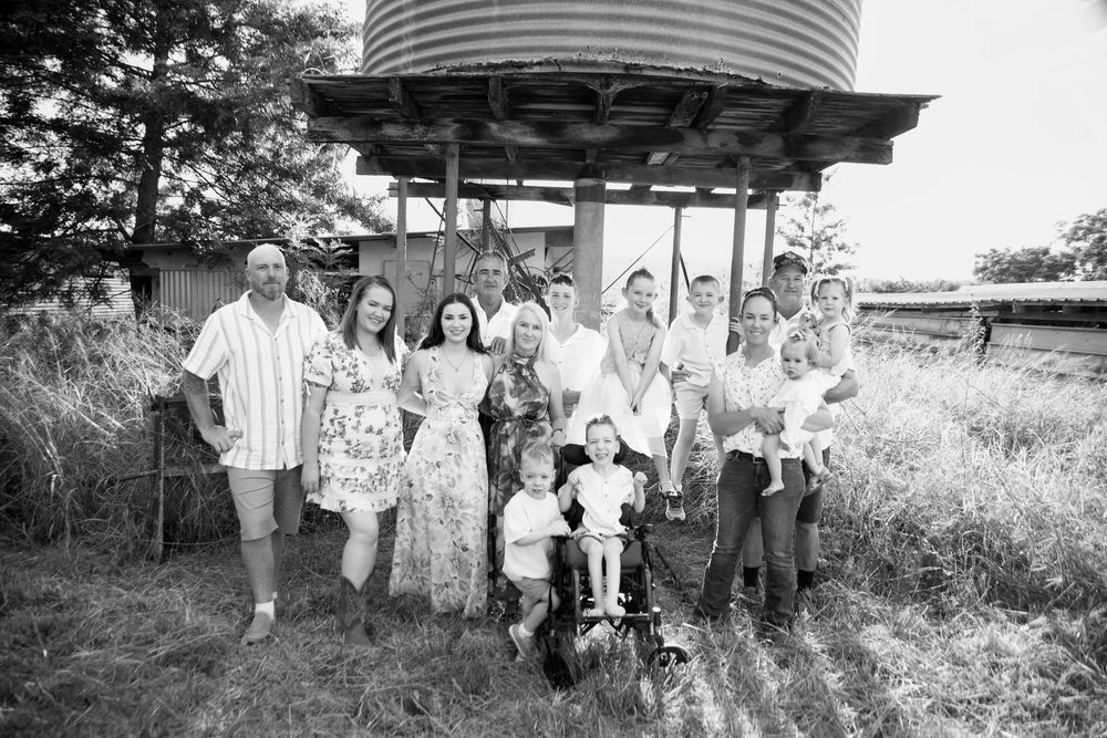 large extended family in the country under a tin water tank making for a beautiful family photo