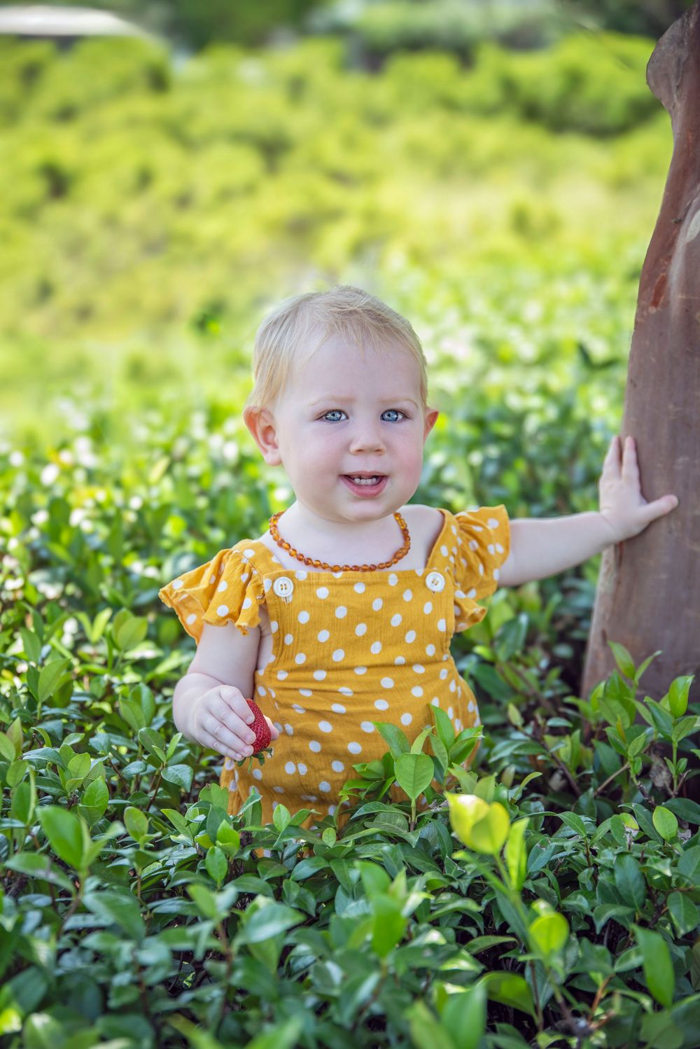 sweet girl sitting in the garden in a yellow dress