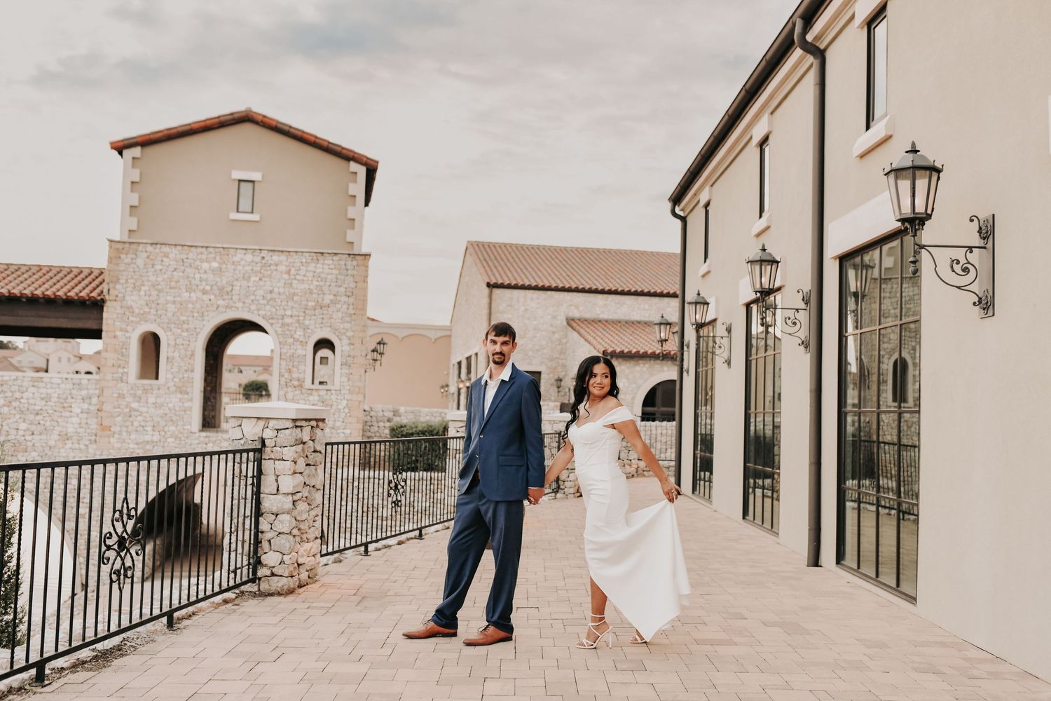 Romantic engagement portrait beside the water with the chapel visible in the distance