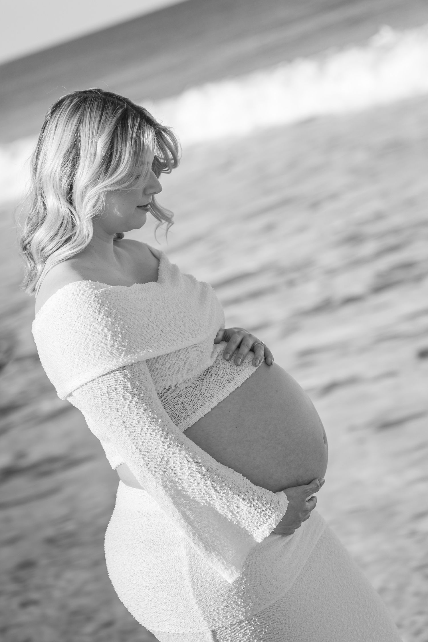 black and white image of pregnant lady on the beach during an afternoon maternity shoot