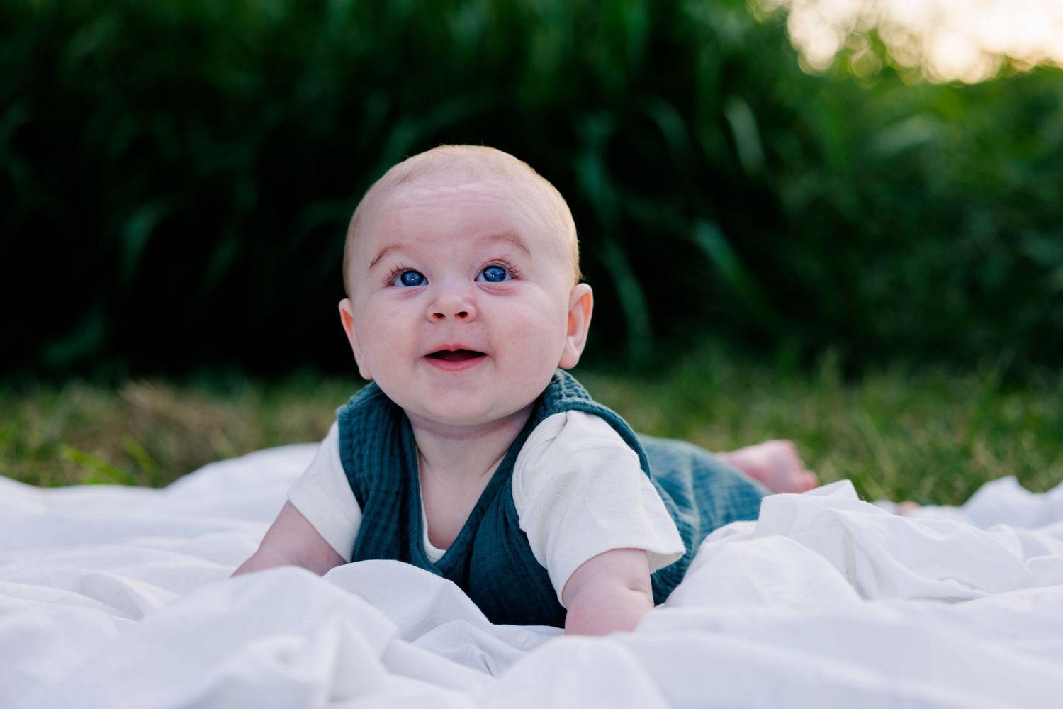 picture of baby on a white sheet on the grass