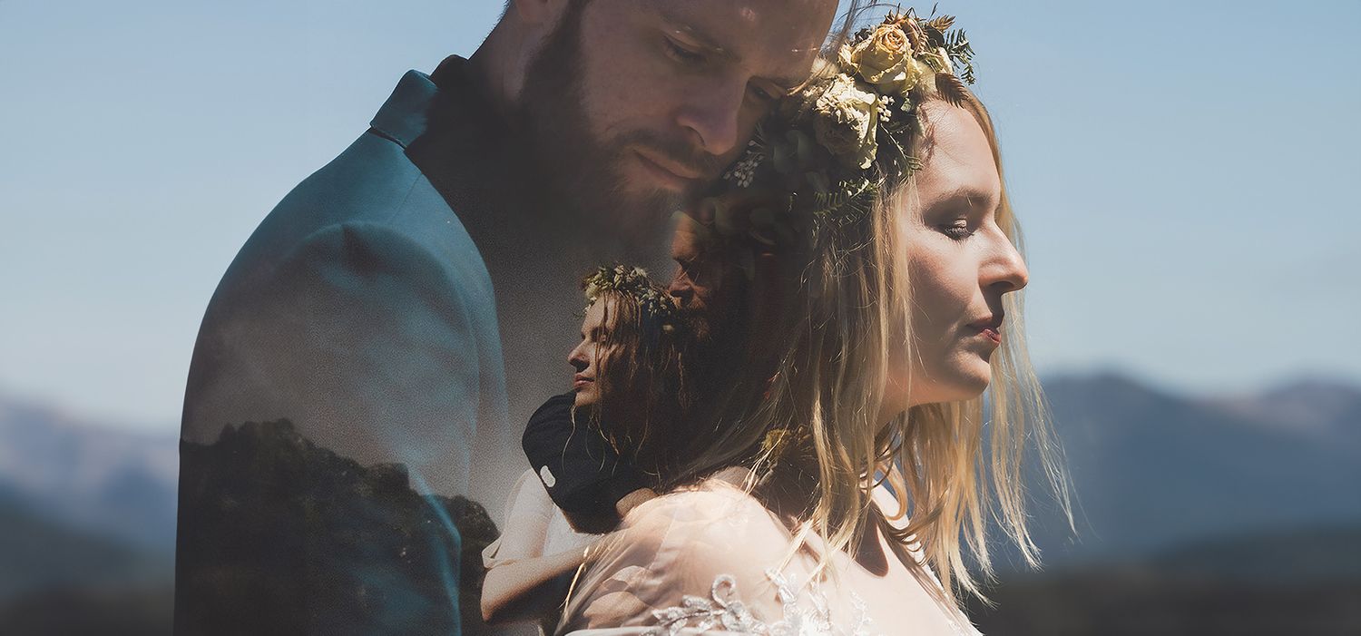 A dreamy portrait of a couple in soft sunlight with mountains in the background.