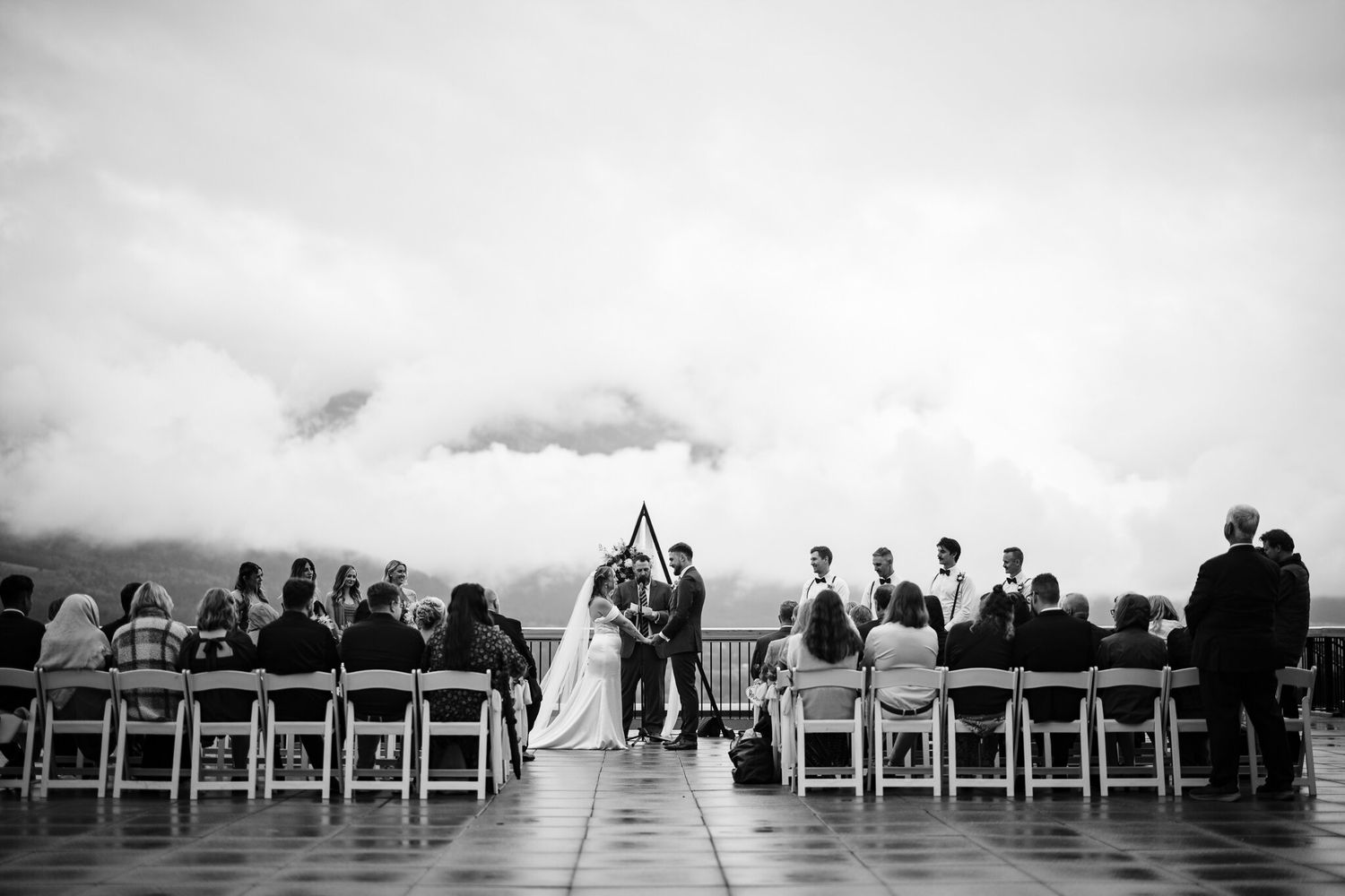 Black and white wide shot of the ceremony on The Vista terrace with Cornerstone Weddings in Canmore