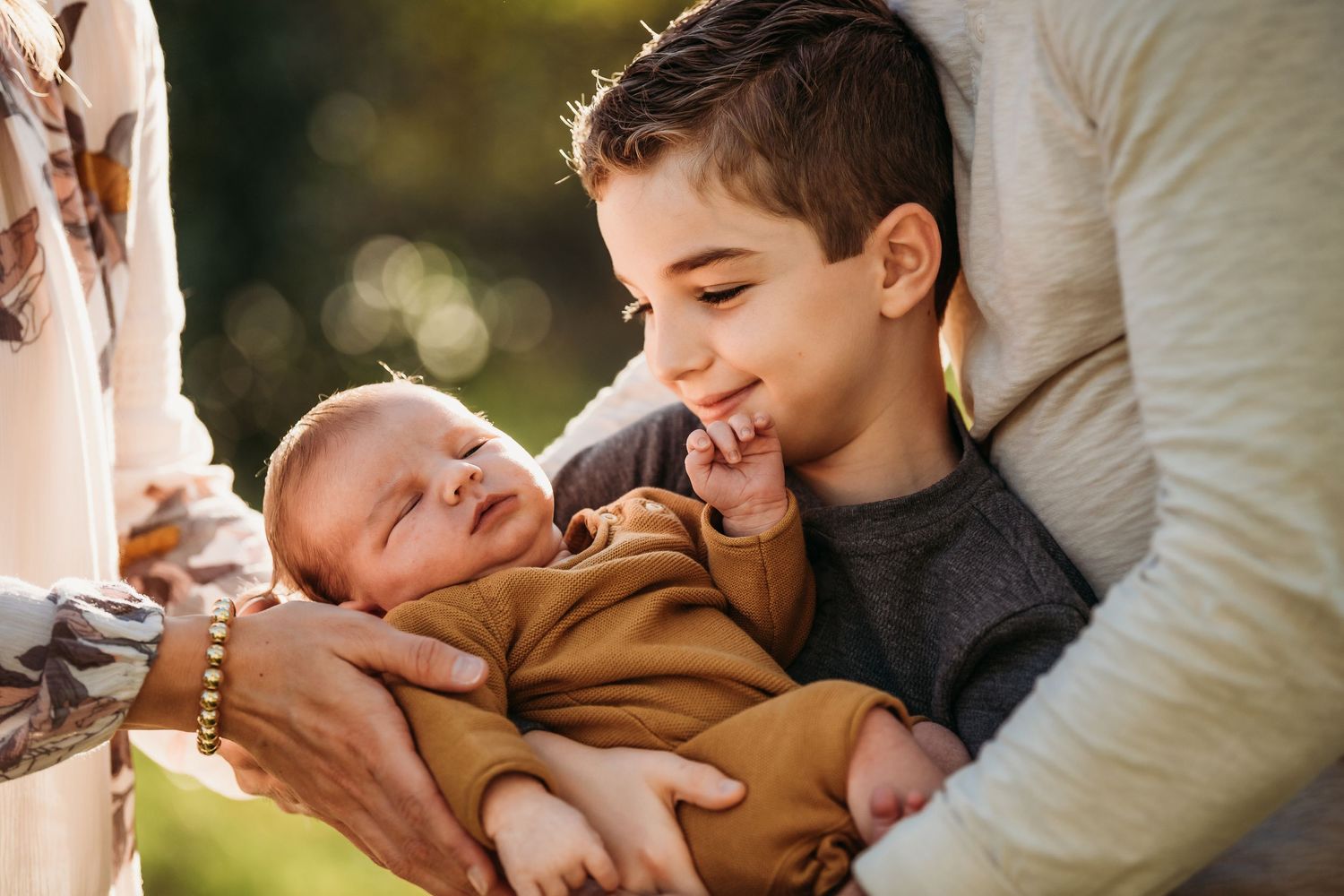 Sweet candid moment between siblings sharing laughter and joy in warm sunlight.