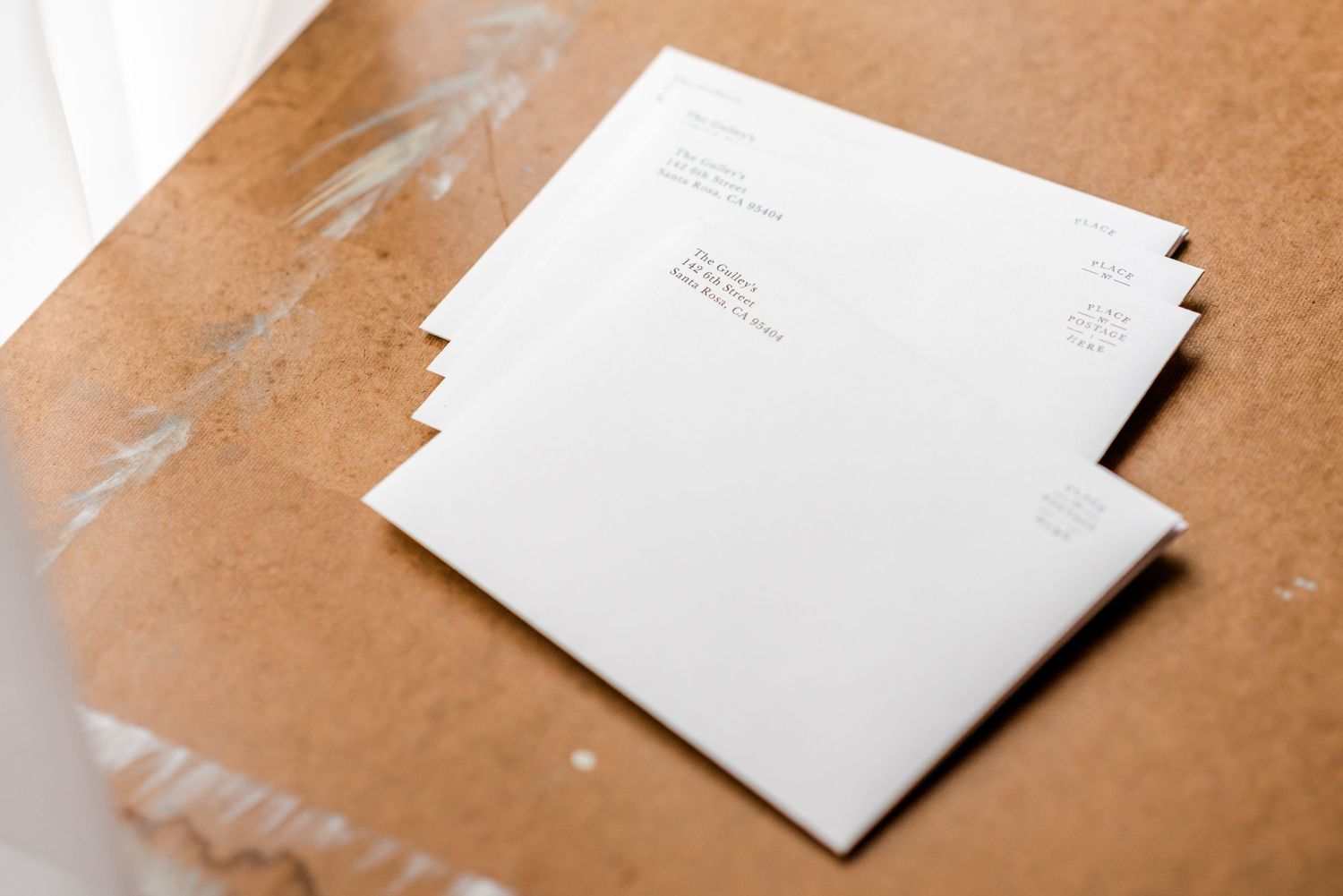 Stack of white mailing envelopes with addresses visible.