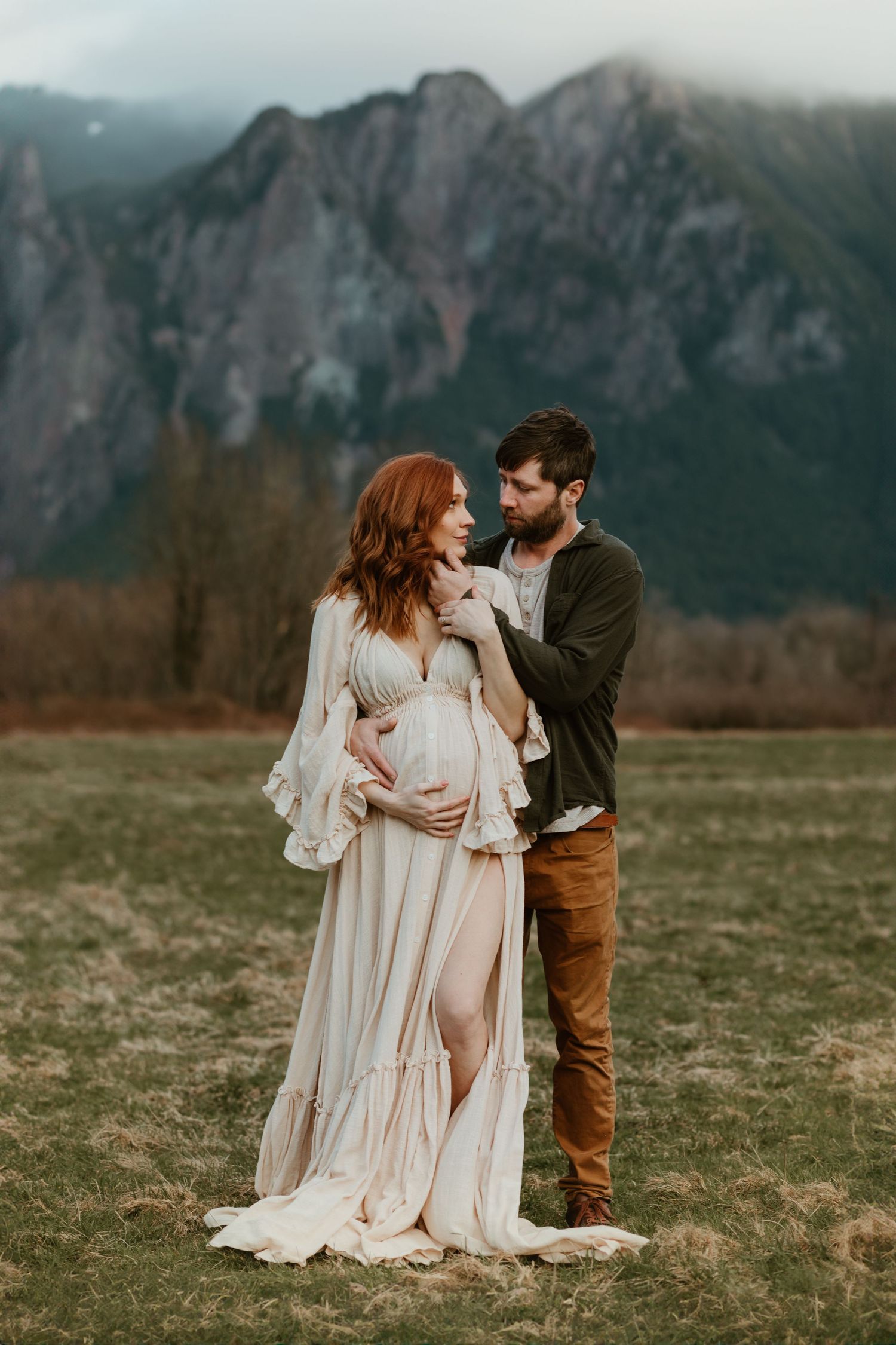 Maternity couple poses in front of mountains in North Bend, WA