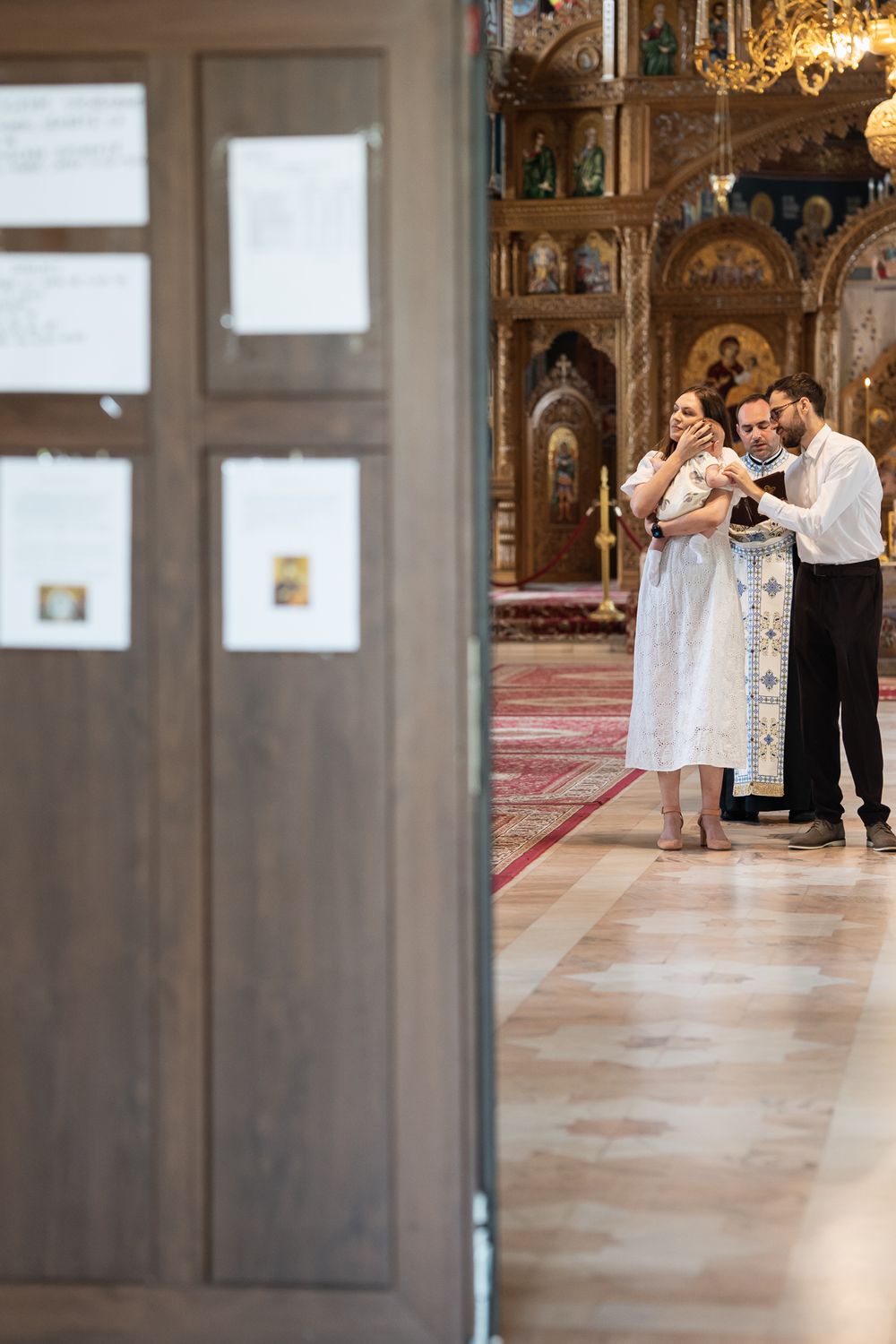Religious ceremony taking place in an elegant church corridor with natural lighting.
