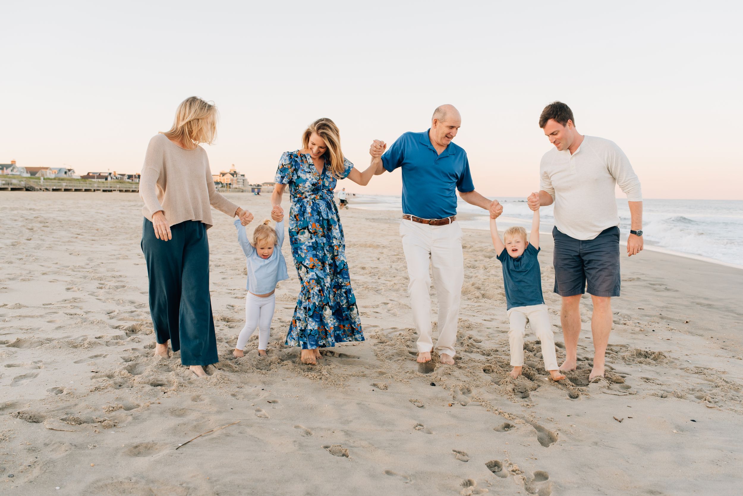 Lauren Marie Photography - Walking down the beach swinging the kids on the beach in Spring Lake NJ