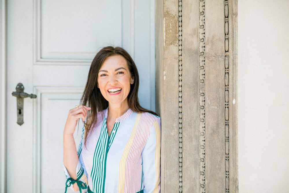 A light and airy portrait featuring a striped dress against a white door backdrop.