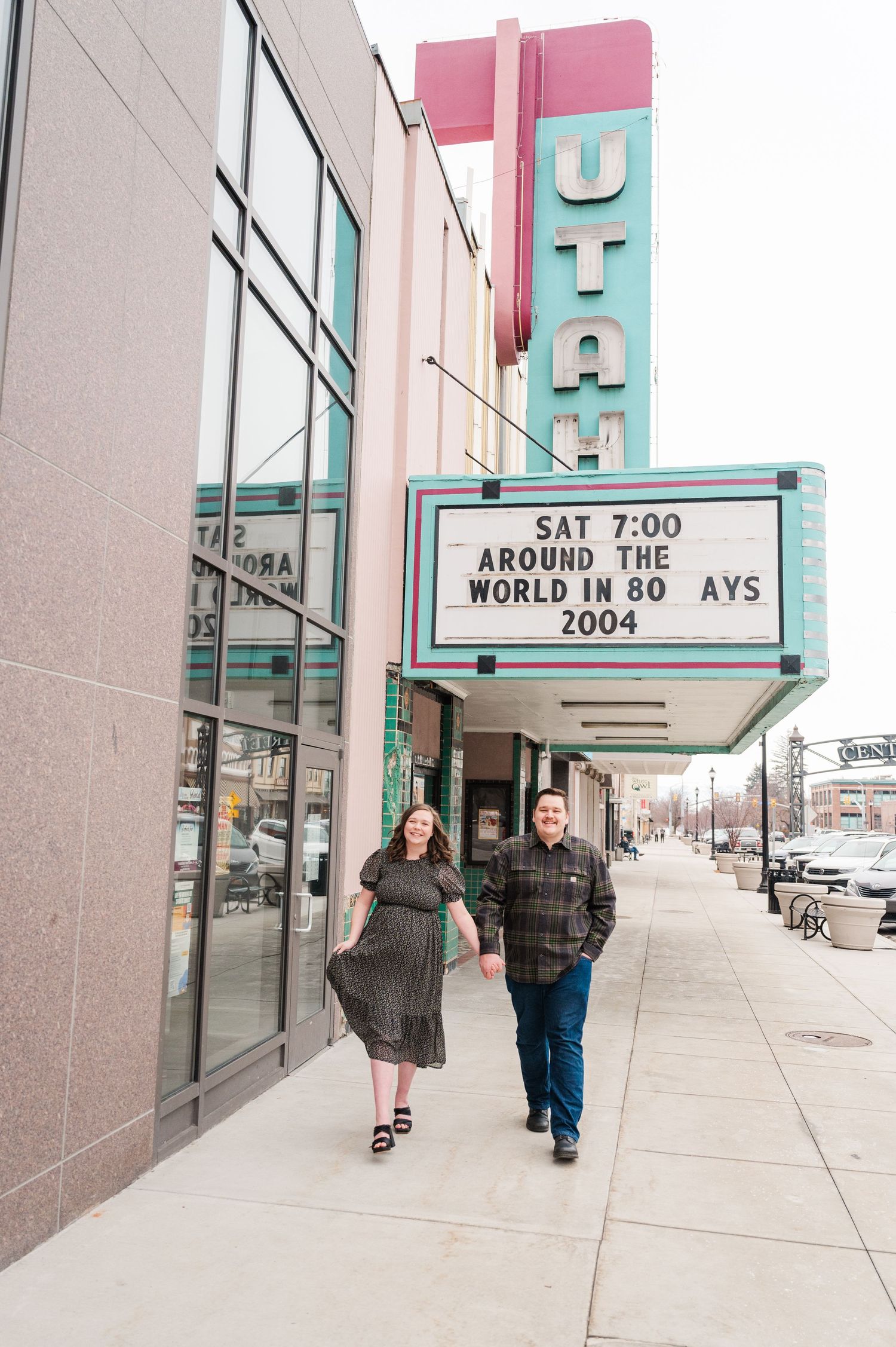 Couple walking outside vintage Utah theater with retro marquee sign.