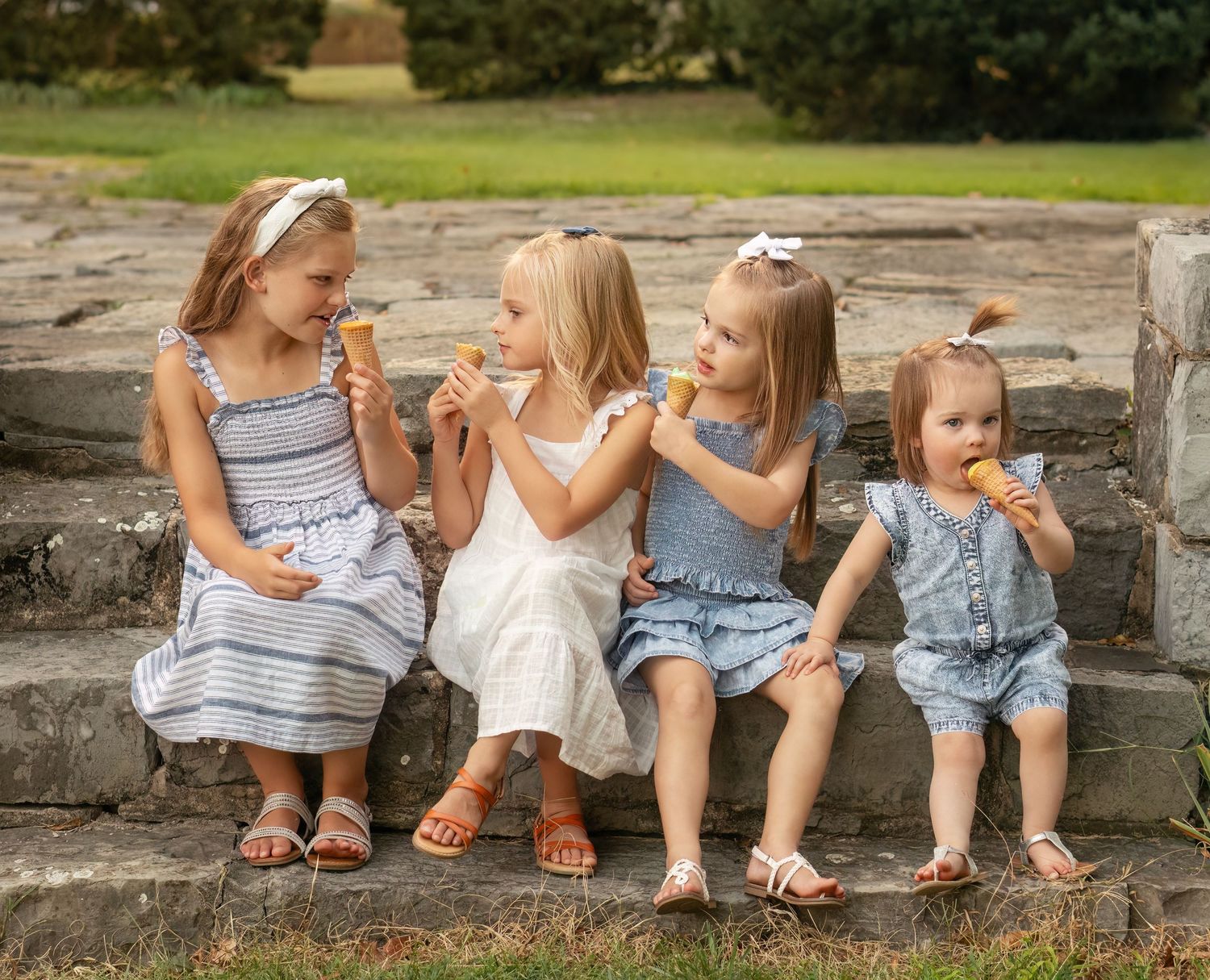 sisters sit together with ice cream cones