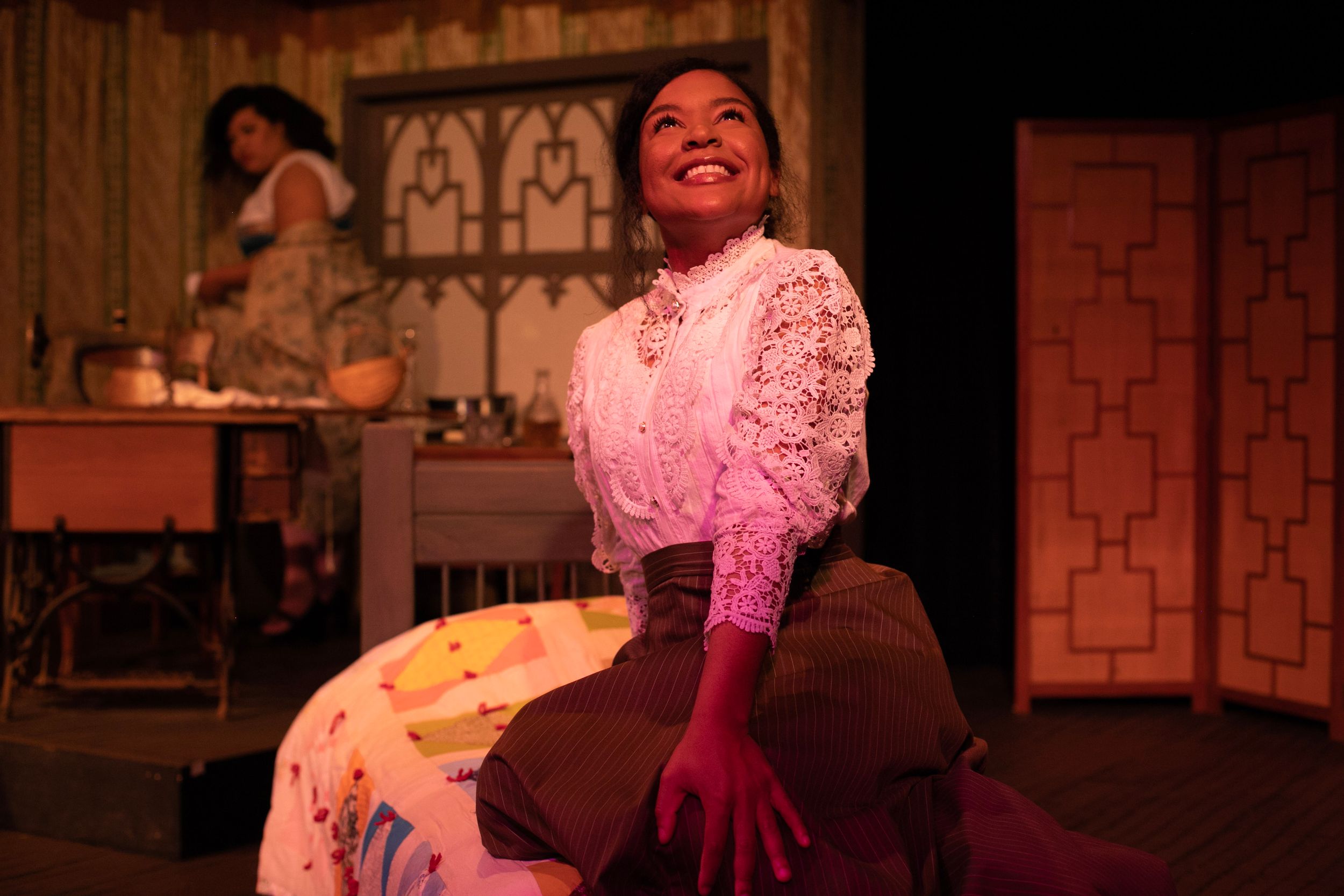 Stage performance scene with warm dramatic lighting and vintage theatrical set design.