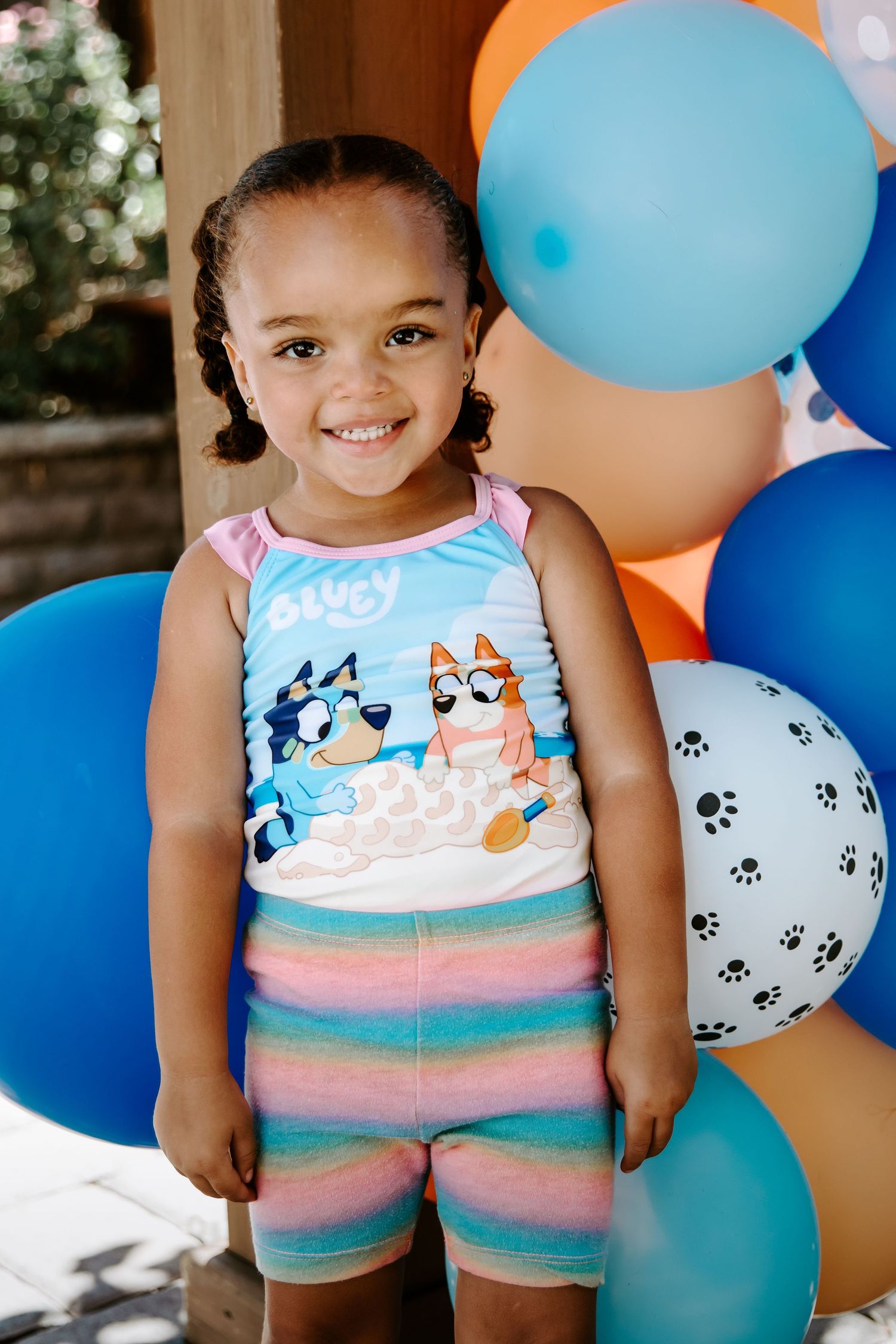 A joyful moment with balloons in orange, blue and white featuring fun paw print patterns.