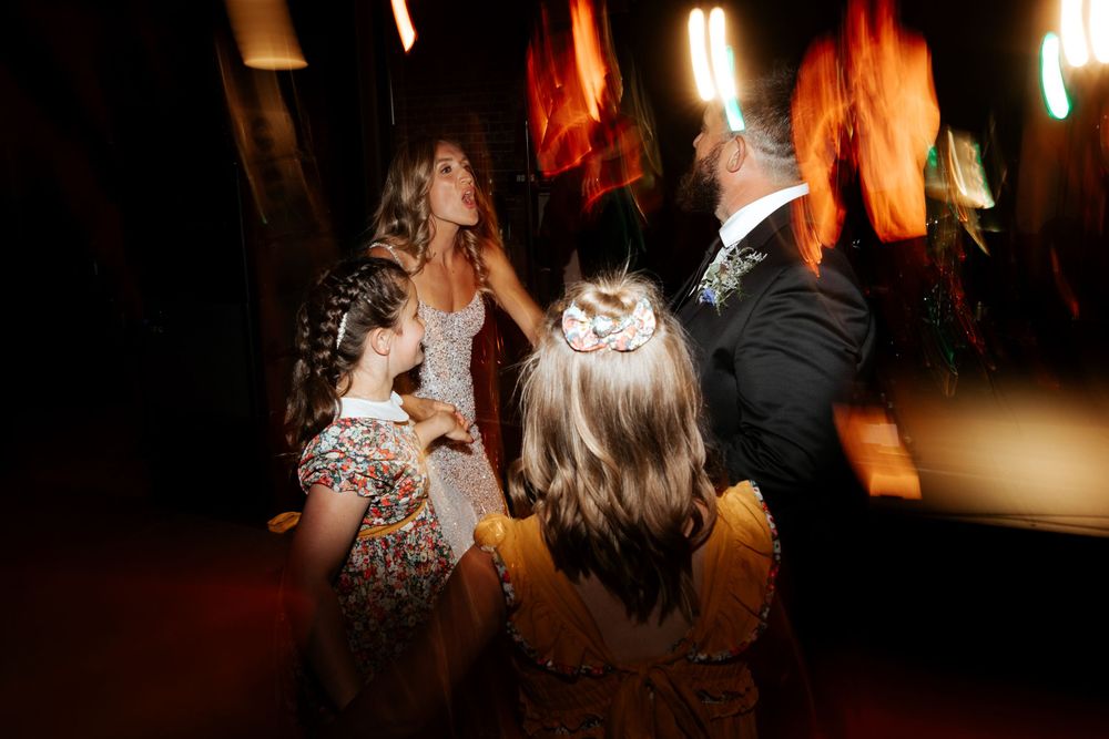Wedding celebration on the dance floor with artistic motion blur and ambient lighting.