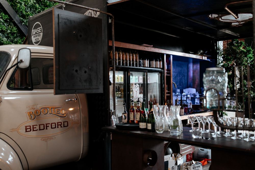Vintage Bedford truck converted into mobile bar with glassware display.