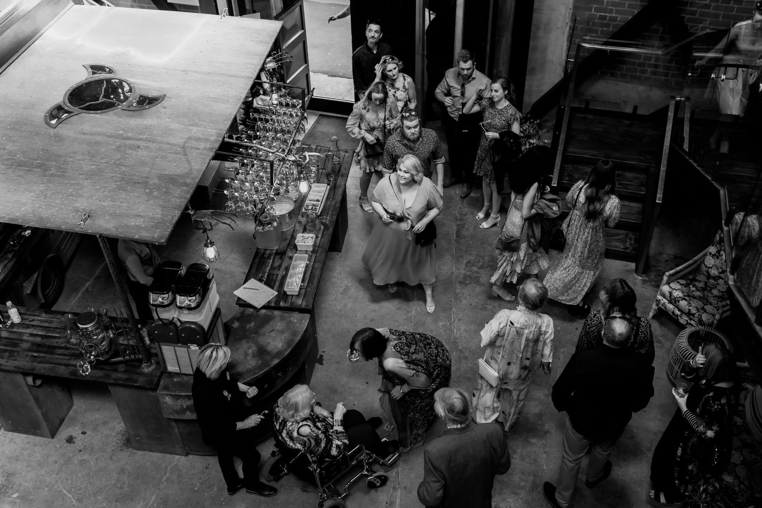 Aerial black and white view of people gathered in an industrial-style event space.