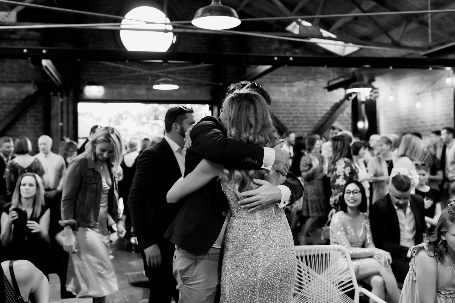 A dance celebration at a wedding reception with guests watching in the background.