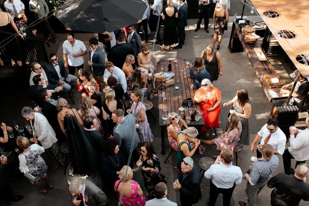 Overhead view of wedding reception crowd mingling around cocktail tables.