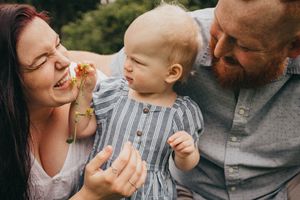 Family sharing a joyful moment together outdoors on a sunny day.