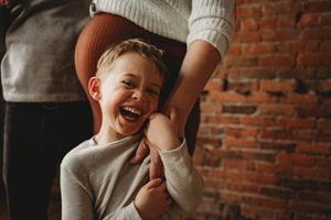 Candid laughter captured against a rustic brick wall backdrop.