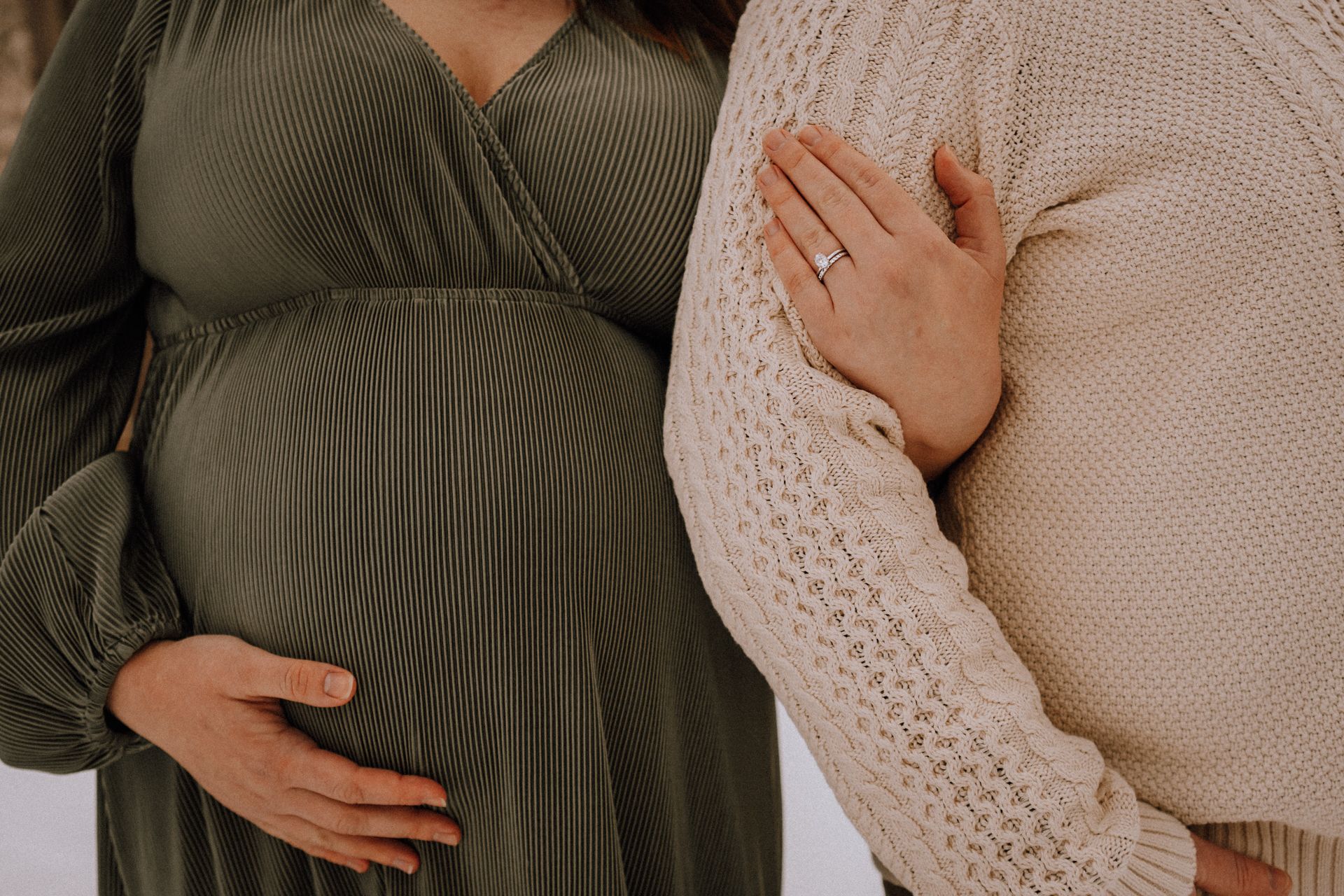 Close-up maternity photo showing couple in cozy winter sweaters.