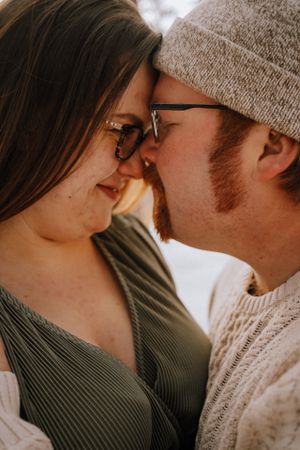 An intimate close-up of a couple sharing a romantic moment in warm lighting.