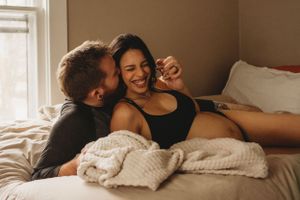 Joyful moment shared in warm sunlight streaming through bedroom window.