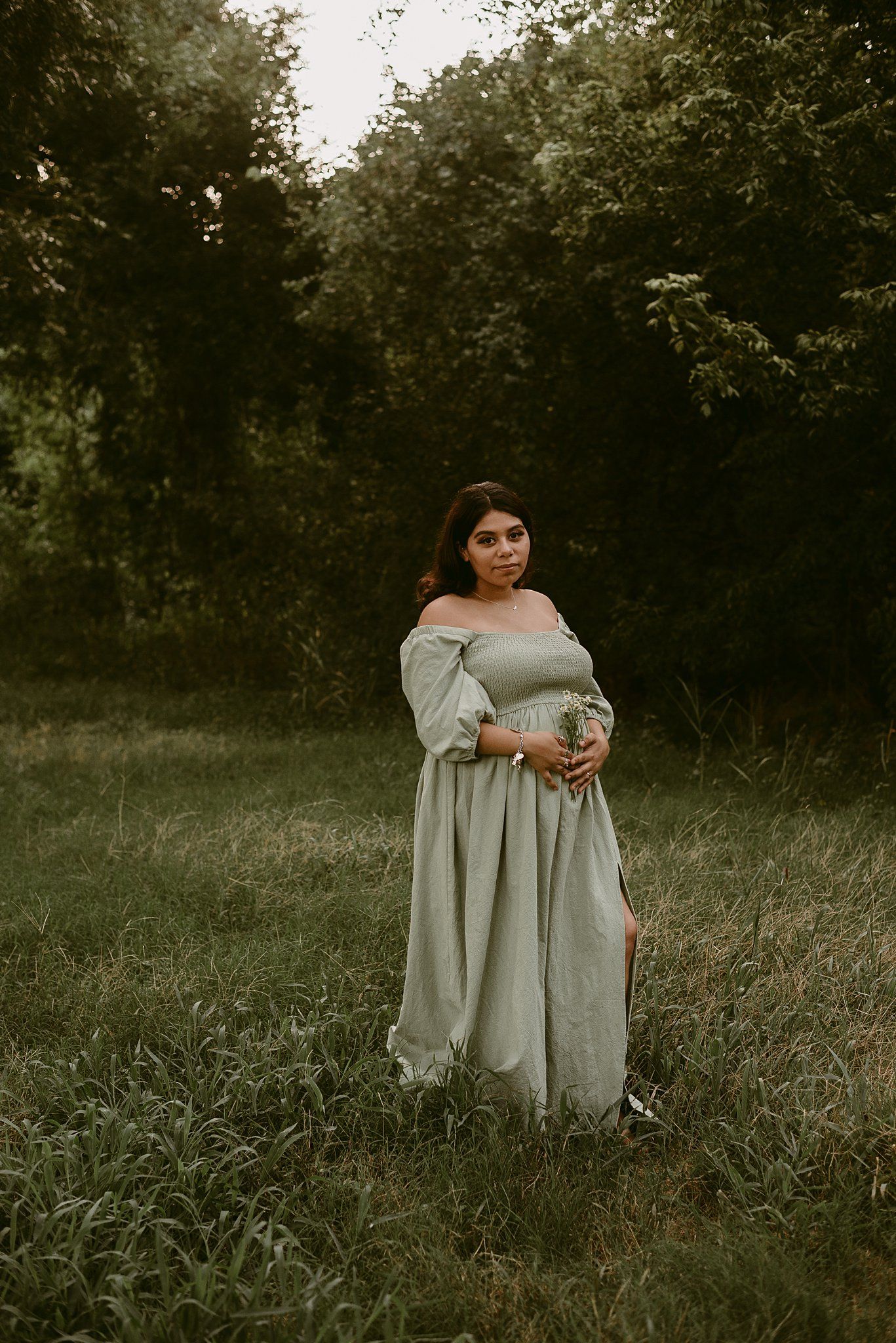 A full-length portrait in tall grass shows someone wearing a romantic off-shoulder gray maxi dress.