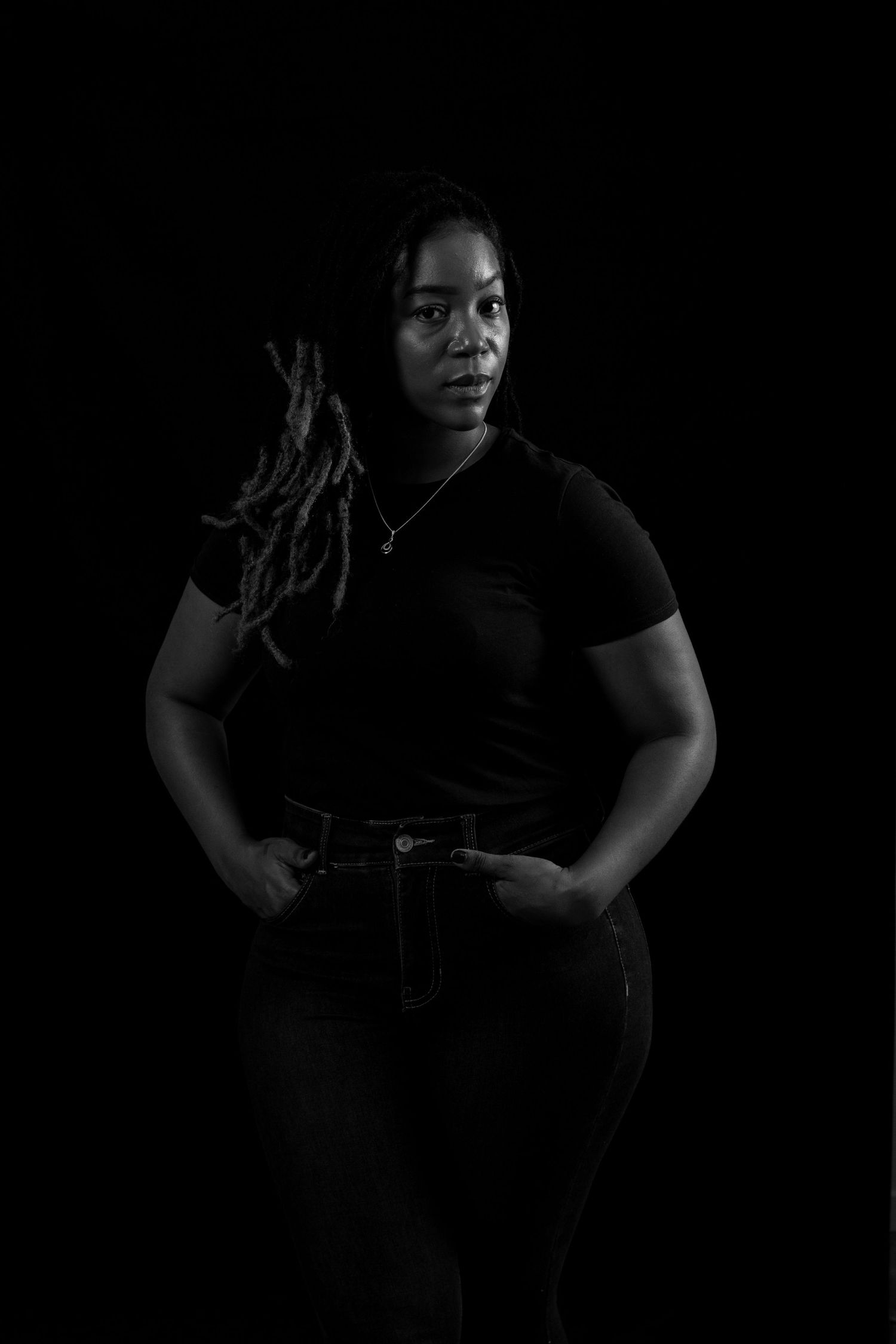 Dramatic black and white portrait against dark background.